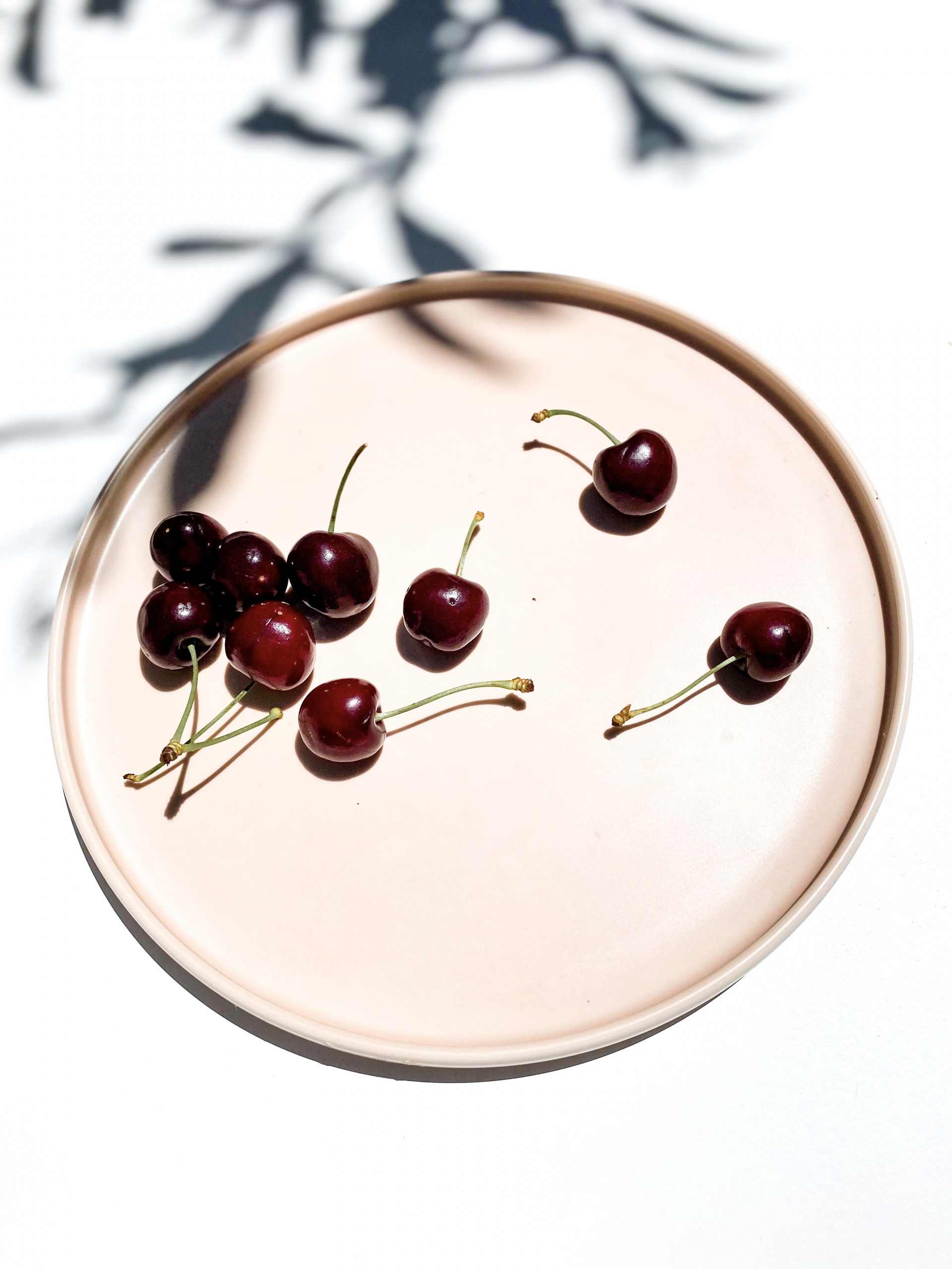 Several cherries sitting on a dish and ready to be eaten to promote restful sleep.
