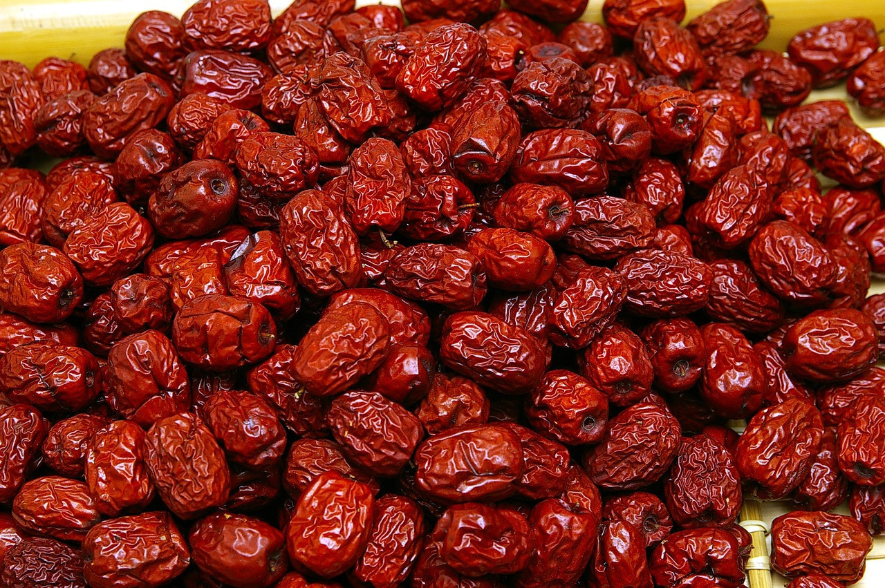 The traditional chinese herb, Jujube dates, is piled on a table.