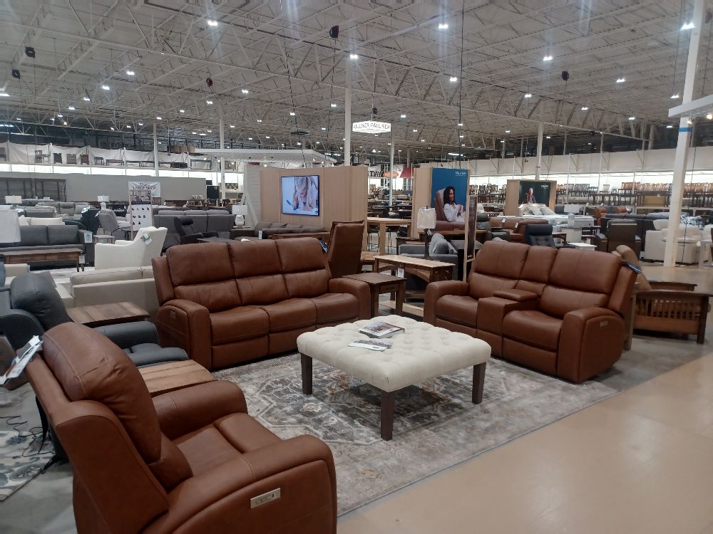 A modern living room with sleek couches and comfortable chairs on display in a furniture store.